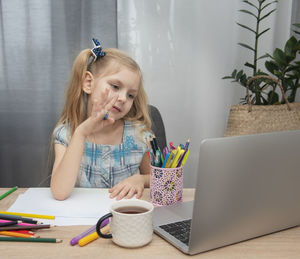 Girl sitting on table at home