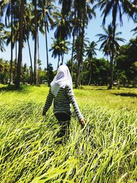 Rear view of woman standing on field