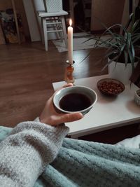 Midsection of woman holding coffee cup on table