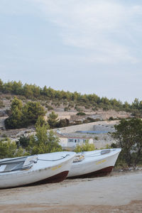 Boats moored on shore against sky