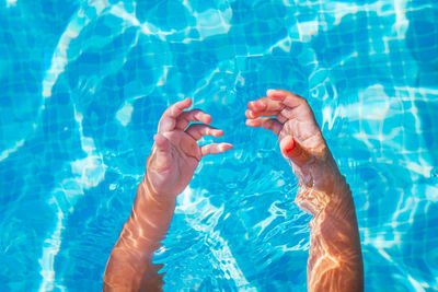 Reflection of hands on water in swimming pool