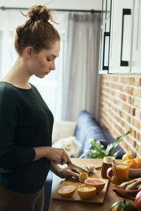 Side view of woman preparing food at home