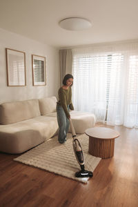 Portrait of young woman sitting on sofa at home