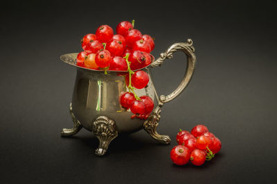 Close-up of red berries on table against black background