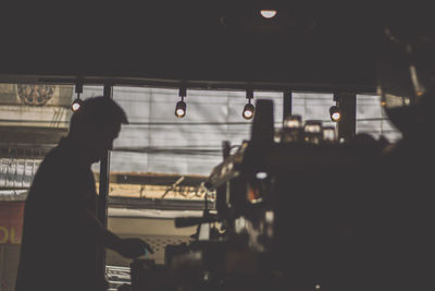 Side view of silhouette man working at bus