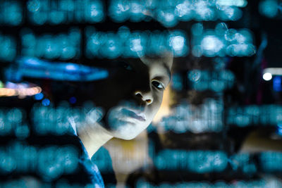 Close-up portrait of boy amidst illuminated lights