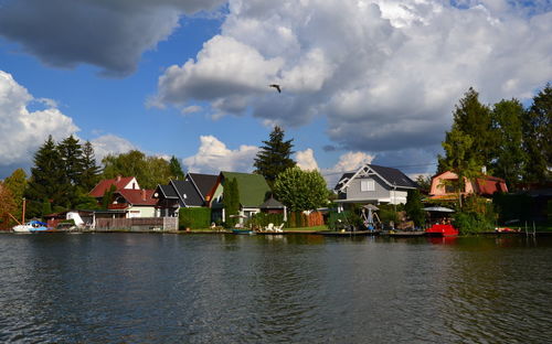 Scenic view of riverside residental area against sky