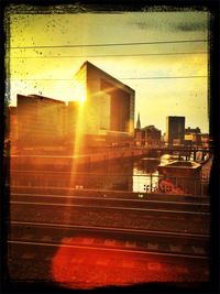 Sun shining through buildings in city