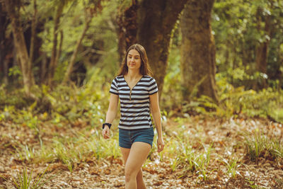 Portrait of young woman standing in forest