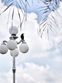 Low angle view of street light against cloudy sky