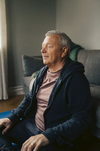 Portrait of young man sitting on sofa at home