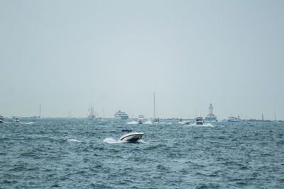 Boat sailing on sea against clear sky