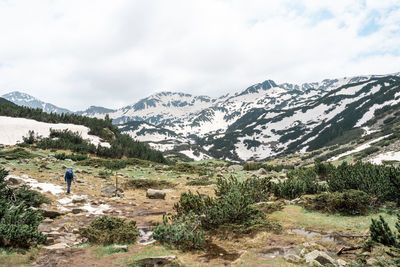 Rear view of man with mountain range against sky