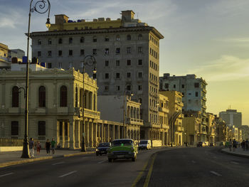 Cars on street in city against sky