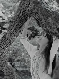 Close-up of girl with tree trunk