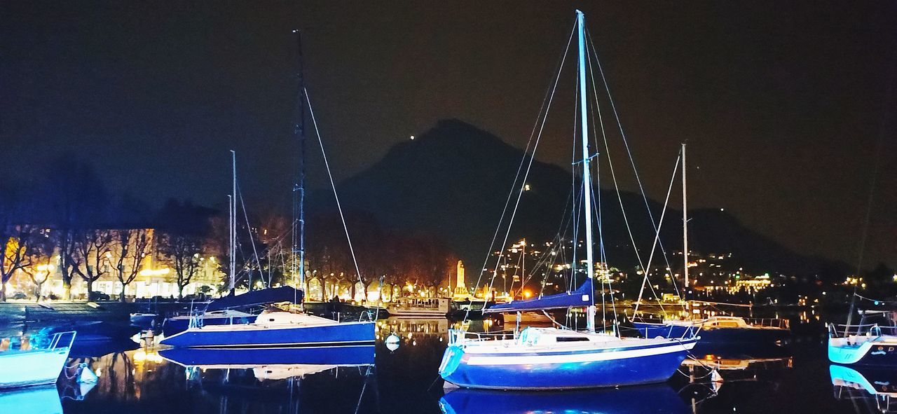 nautical vessel, marina, water, transportation, night, moored, mode of transportation, sailboat, harbor, illuminated, boat, pole, dock, no people, mast, sea, ship, nature, sky, vehicle, evening, watercraft, outdoors, architecture, reflection, travel destinations, yacht