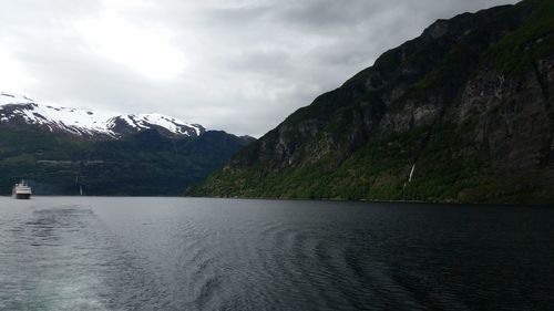 Scenic view of lake by mountains against sky