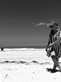 Woman on beach against sky