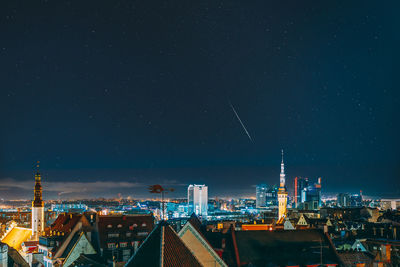 Illuminated cityscape against sky at night