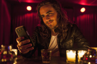 Young man checking his cell phone while at a nightclub