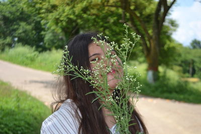 Portrait of woman with pink flowers against blurred background