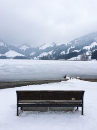 Scenic view of frozen lake by mountains against sky