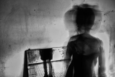 Blurred motion of person standing against wall