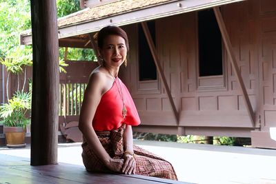 Portrait of smiling woman wearing traditional clothes while sitting at home