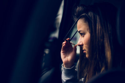 Close-up of teenage girl wearing sunglasses while sitting in car