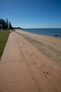 Scenic view of beach against clear blue sky