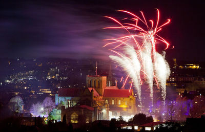 Firework display over cityscape at night