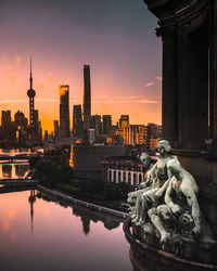 Statue of buildings against sky during sunset