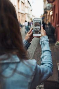 Young woman having video call talking while walking downtown wearing the face mask to avoid virus