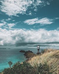 Rear view of man looking at sea against sky
