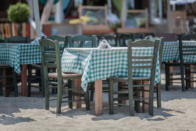 Empty chairs and tables at beach 