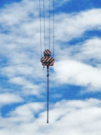 Low angle view of pulley against sky