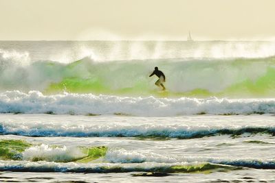 Man surfing in sea against sky