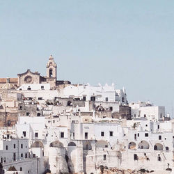 Buildings in town against clear sky