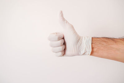 Low section of man holding hands over white background