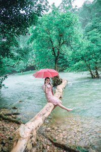 Woman on wet tree in forest