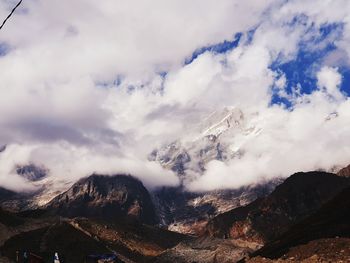 Scenic view of snowcapped mountains against cloudy sky