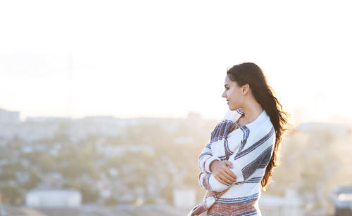 Side view of young woman looking away outdoors