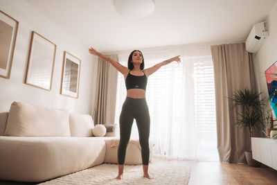 Full length of woman exercising at home