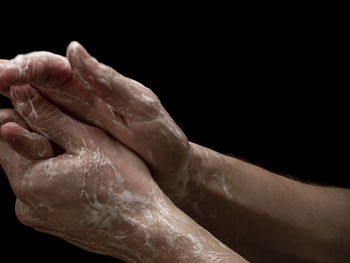 Close-up of hand over black background