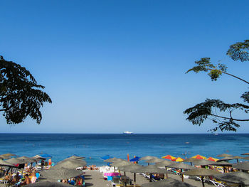Scenic view of beach against clear blue sky
