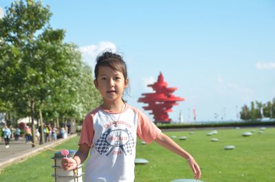 Portrait of girl holding candy while standing at park