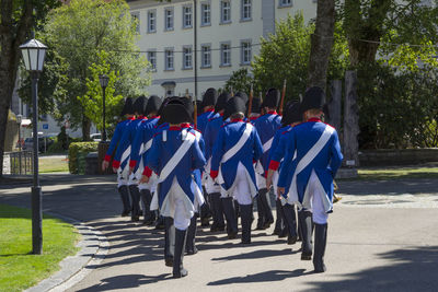 Rear view of people walking on street in city