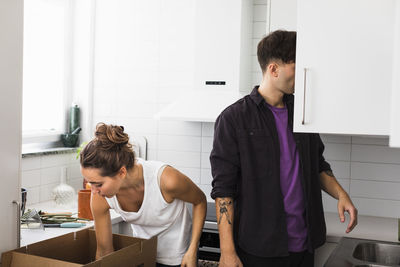 Couple unpacking boxes in kitchen