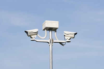 Low angle view of telephone pole against clear blue sky