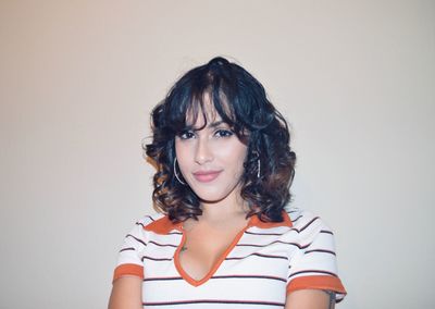 Portrait of smiling young woman against white background